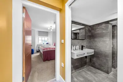 a bathroom with a shower and a sink and a mirror at RÌGH Properties - Luxury West End Artisan Apartment in Edinburgh