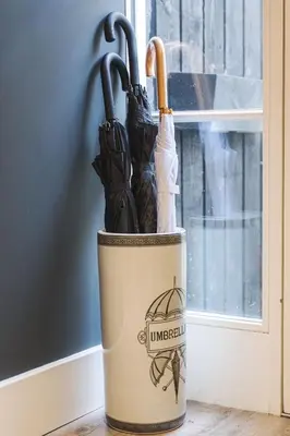 a bucket filled with umbrellas sitting next to a window at RÌGH Properties - Luxury West End Artisan Apartment in Edinburgh