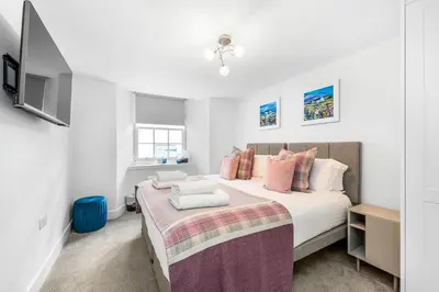 a bedroom with a large bed with pink pillows at RÌGH Properties - Luxury West End Artisan Apartment in Edinburgh