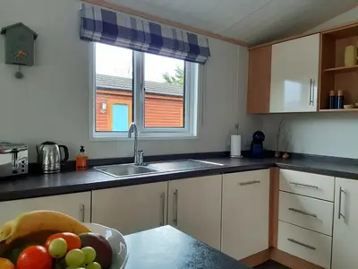 a kitchen with a bowl of fruit on the counter at Sycamore Lodge Auchterarder in Auchterarder