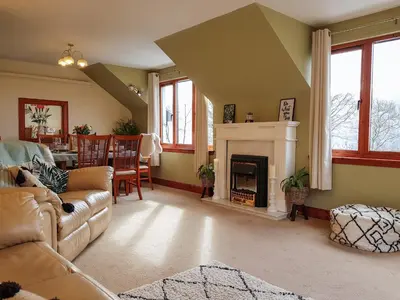 a living room with a couch and a fireplace at The Old Post Office On Loch Tay in Stron-fearnan