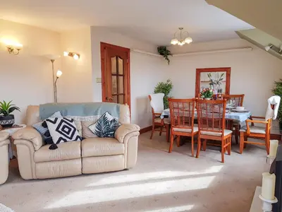 a living room with a couch and a table at The Old Post Office On Loch Tay in Stron-fearnan