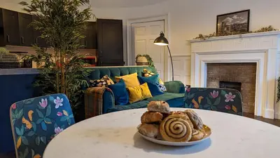 a living room with a table and a couch at Slateford House 1770 Luxury Aparthotel by The House of Danu in Edinburgh