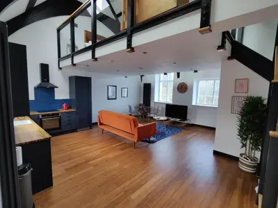 an open living room with a couch and a table at Slateford House 1770 Luxury Aparthotel by The House of Danu in Edinburgh