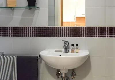 a white sink in a bathroom with a mirror at Studios and Ensuite Bedrooms with Shared Kitchen at Fountainbridge in Edinburgh in Edinburgh