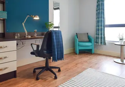 an office with a chair and a desk with a blue wall at Studios and Ensuite Bedrooms with Shared Kitchen at Fountainbridge in Edinburgh in Edinburgh