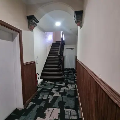a hallway with stairs in an old building at The Beath Inn in Cowdenbeath