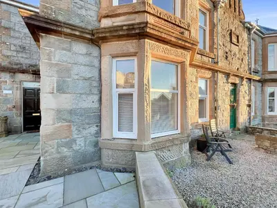 a stone building with a window and a chair at No.3 The Villa in Oban