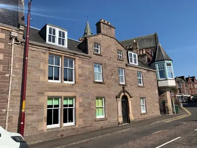 an old brick building on the corner of a street at Squirrel Away At Leven House in Crieff