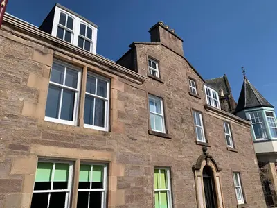 an old brick building with many windows on it at Squirrel Away At Leven House in Crieff
