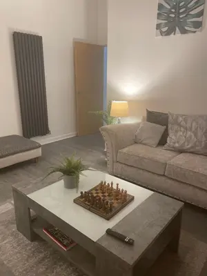 a living room with a chessboard on a coffee table at THE PAISLEY PENTHOUSE - ABBEY VIEW in Paisley