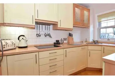 a kitchen with white cabinets and a counter top at Best location in town, it is all on the doorstep. in Ayr