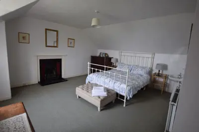 a bedroom with a bed and a fireplace at Rural Farmhouse on Kintyre, West Coast hidden gem in Kildalloig