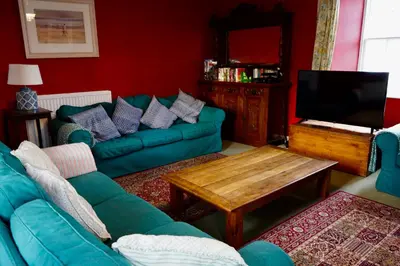 a living room with a green couch and a tv at Rural Farmhouse on Kintyre, West Coast hidden gem in Kildalloig