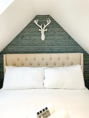 a bedroom with a bed with a deer head on the wall at Stunning Loft Apartment South Queensferry High St Bridge Views! in Queensferry