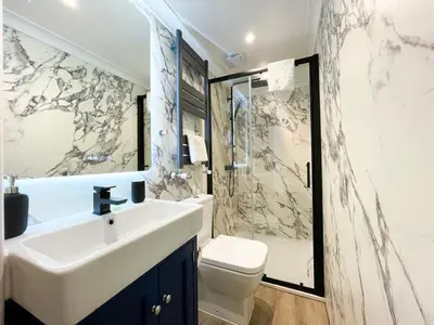a bathroom with a sink and a toilet and a shower at Stunning Loft Apartment South Queensferry High St Bridge Views! in Queensferry