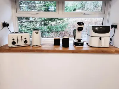 three coffee machines sitting on a counter next to a window at Riverside Cottage in Larkhall