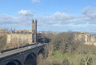 a city with a bridge and a building with a clock tower at West End Townhouse in Edinburgh