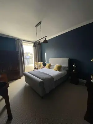 a bedroom with a bed and a blue wall at West End Townhouse in Edinburgh