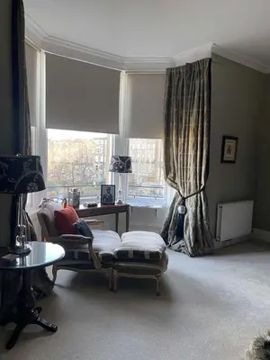 a living room with a couch and a window at West End Townhouse in Edinburgh