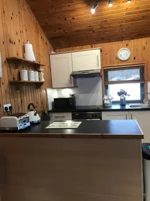 a kitchen with a counter and a clock on the wall at Gulls Island in Morenish