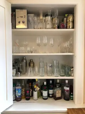 a cabinet filled with glasses and wine glasses at Spacious 3 bed flat in the heart of the west end. in Glasgow