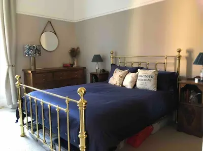 a bedroom with a bed with blue sheets and pillows at Spacious 3 bed flat in the heart of the west end. in Glasgow