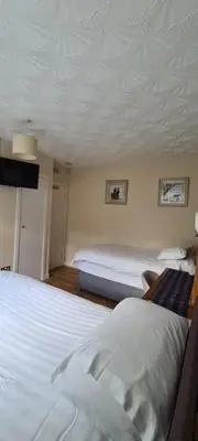 a bedroom with two beds and a white ceiling at Lowefield B&B in Plean