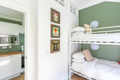 a bedroom with bunk beds and a kitchen at Squirrel Lodge 40 with Hot Tub in Newton Stewart