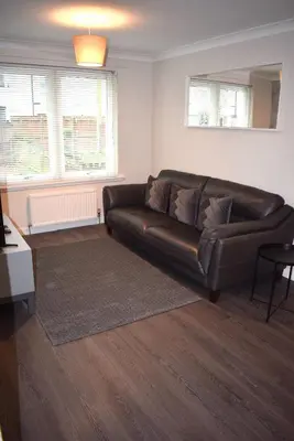 a brown leather couch in a living room at Kelpies Serviced Apartments- Cromwell Apt in Falkirk
