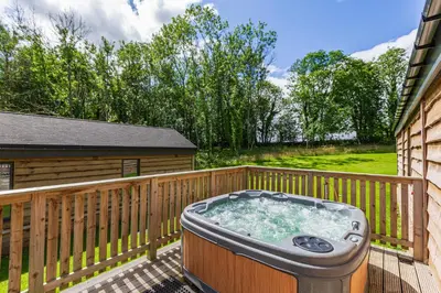 a hot tub on the deck of a house at Squirrel Lodge 41 with Hot Tub in Newton Stewart