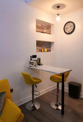 a kitchen with a table and two chairs and a clock at Modern flat near city centre. in Edinburgh