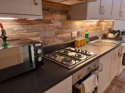 a kitchen counter with a stove and a microwave at Modern flat near city centre. in Edinburgh