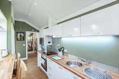 a kitchen with white cabinets and wooden counter tops at Squirrel Lodge 42 with Hot Tub in Newton Stewart
