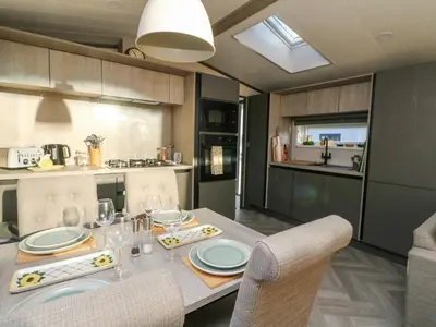 a kitchen with a table with chairs and a dining room at Hollybirch in Crieff