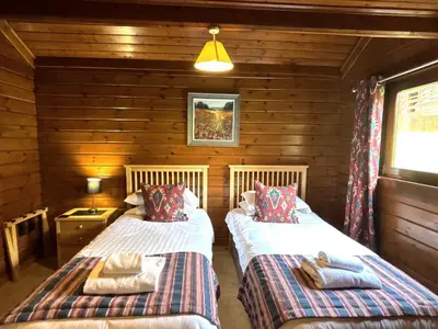 a bedroom with two beds in a log cabin at Lady Galloway 28 with Hot Tub in Newton Stewart