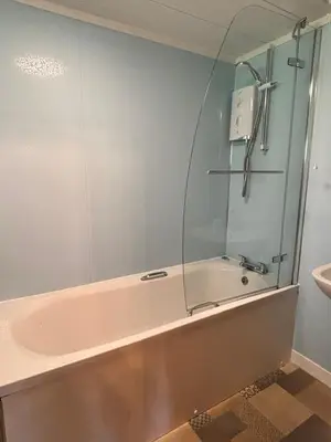 a bathroom with a bath tub and a sink at Lady Galloway 29 with Hot Tub in Newton Stewart