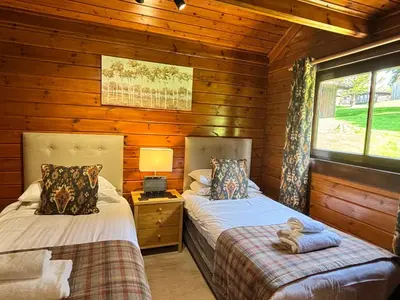 a bedroom with two beds in a log cabin at Lady Galloway 29 with Hot Tub in Newton Stewart
