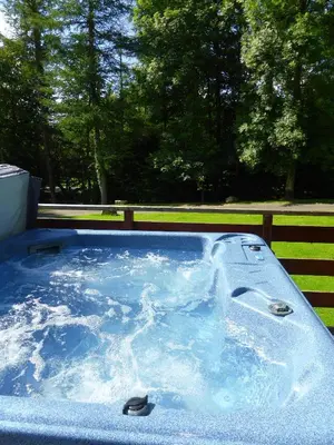 a hot tub with blue water in a yard at Lady Galloway 29 with Hot Tub in Newton Stewart