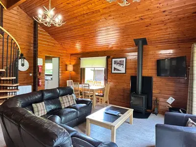 a living room with a couch and a stove at Lady Galloway 29 with Hot Tub in Newton Stewart