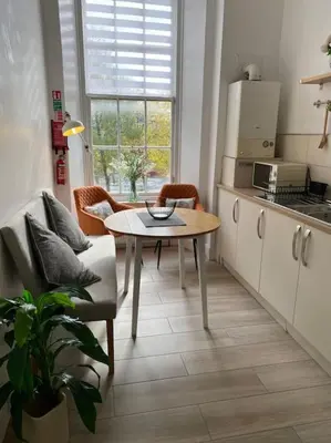 a kitchen with a table and a chair and a table at GLASGOW WEST END 5 MIN WALK TO SECC AND HYDRO in Glasgow