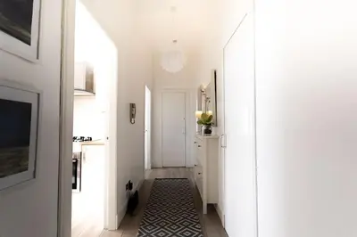 a hallway with white walls and a black and white rug at GLASGOW WEST END 5 MIN WALK TO SECC AND HYDRO in Glasgow