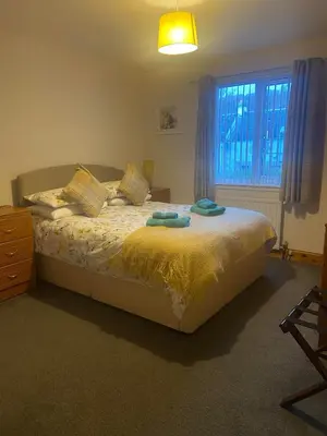 a bedroom with a bed with two towels on it at Cosy detached house in central location in Oban