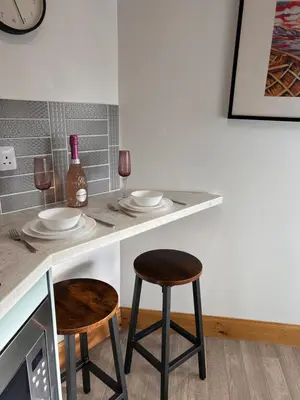 a counter with two stools and two glasses of wine at Glenshee Annexe, Oban. in Oban