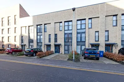 a brick building with cars parked in front of it at Stylish 3BR Home with Garden & Free Parking - Near O2 Academy & City Centre in Glasgow