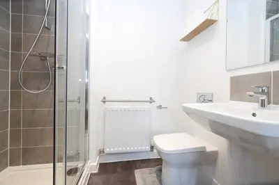 a bathroom with a toilet and a sink and a shower at Stylish 3BR Home with Garden & Free Parking - Near O2 Academy & City Centre in Glasgow