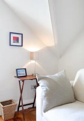 a living room with a white couch and a table with a laptop at The Botanics Residence in Edinburgh