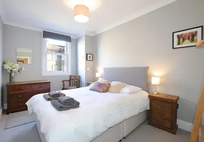 a bedroom with a large white bed and a window at The Botanics Residence in Edinburgh