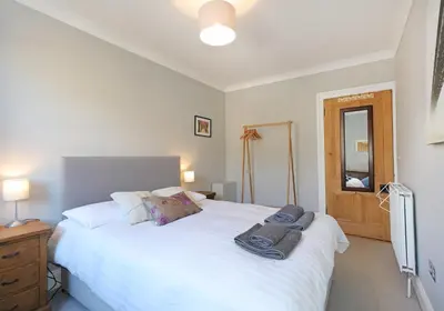 a bedroom with a large white bed with towels on it at The Botanics Residence in Edinburgh