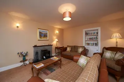 a living room with a couch and a fireplace at Home Farm Cottages, Glendaruel, Argyll. Scotland in Clachan of Glendaruel